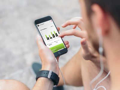 Person som använder mobiltelefon för att hantera statistik och nyhetsuppdateringar i Föreningshäftets system